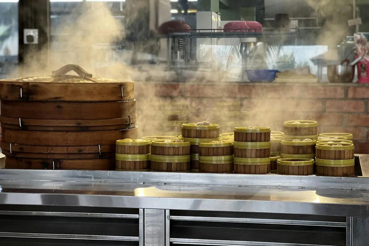 A bamboo steamer basket with steam rising