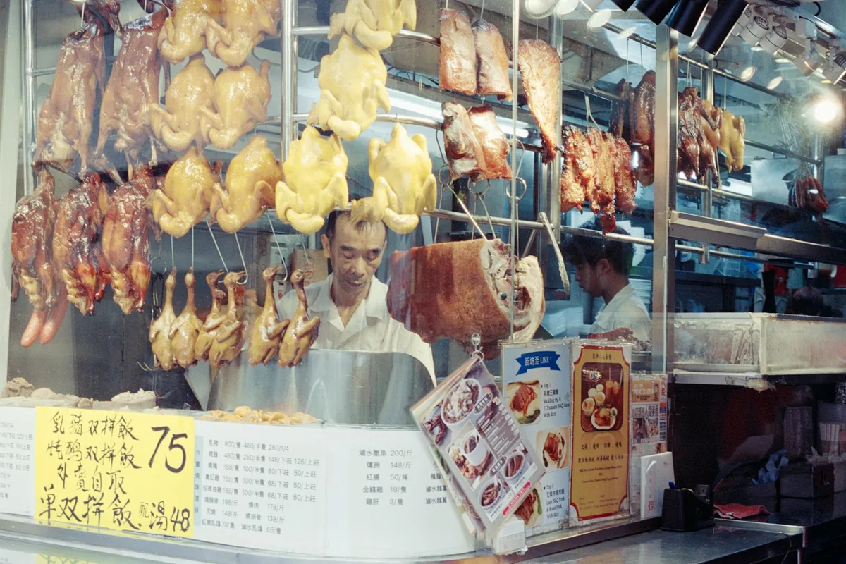 A Chinese BBQ shop window with hanging meats