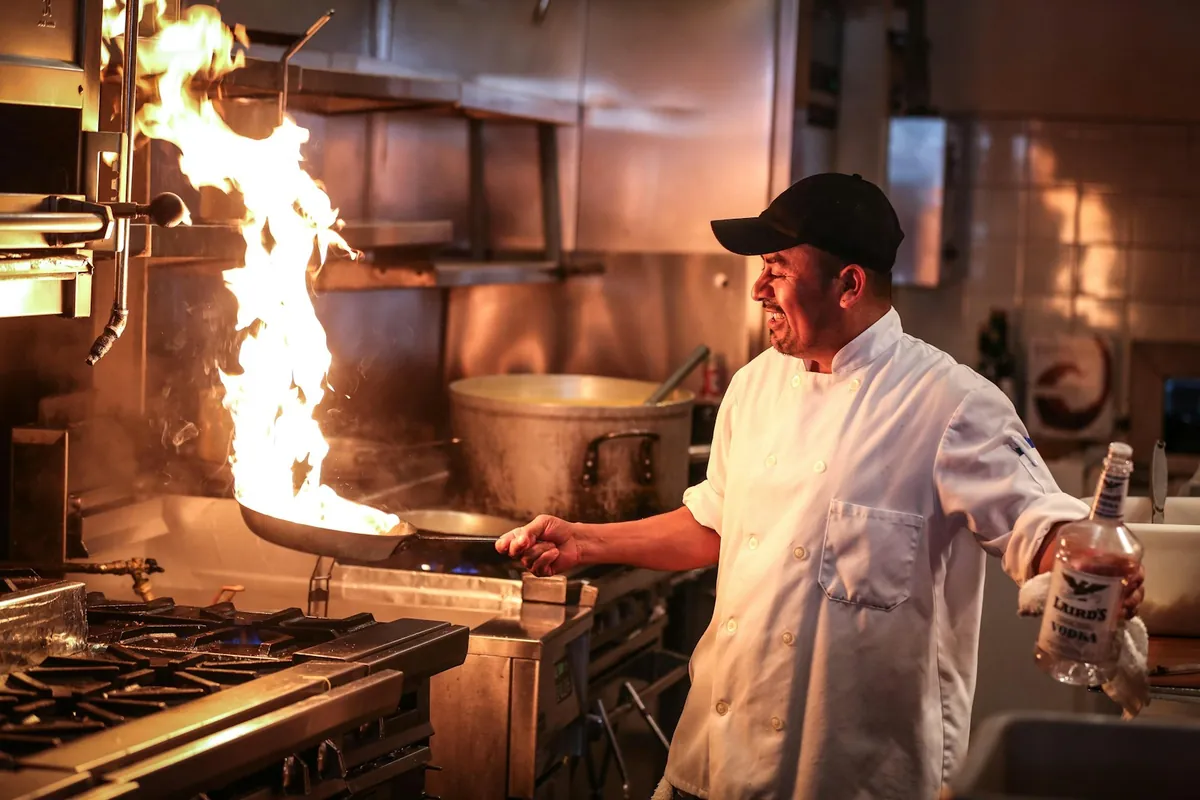 A cook tossing food in a wok