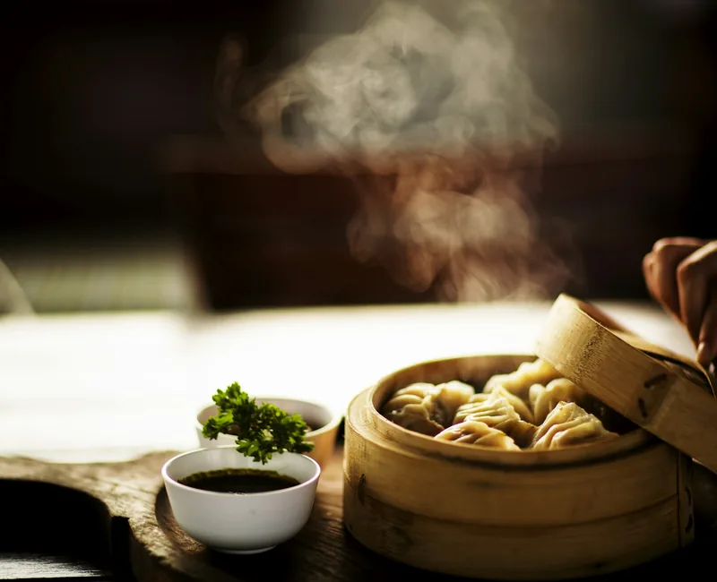 Freshly steamed dumplings resting in a bamboo steamer