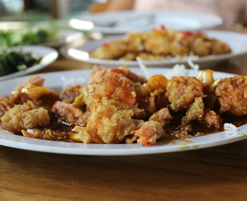 Crispy fried chicken pieces in a glossy sauce served in a bowl