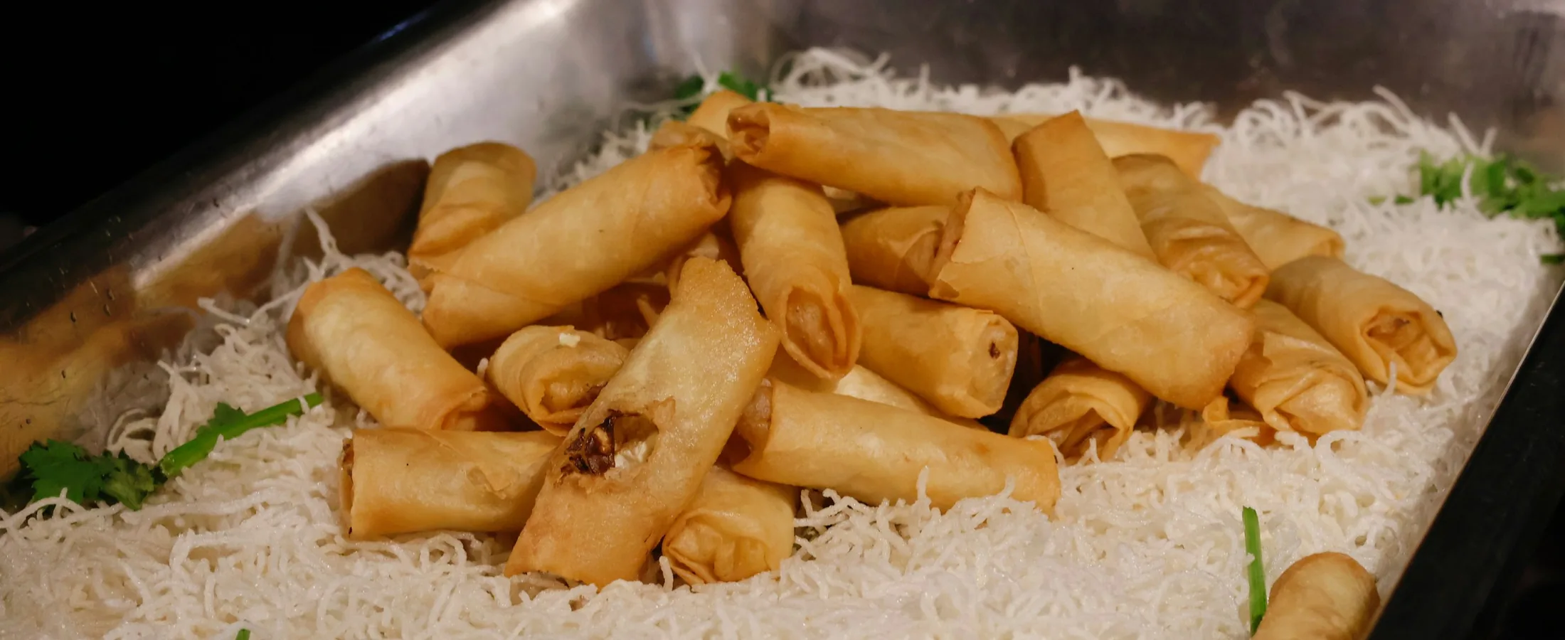 Golden fried egg rolls stacked on a plate