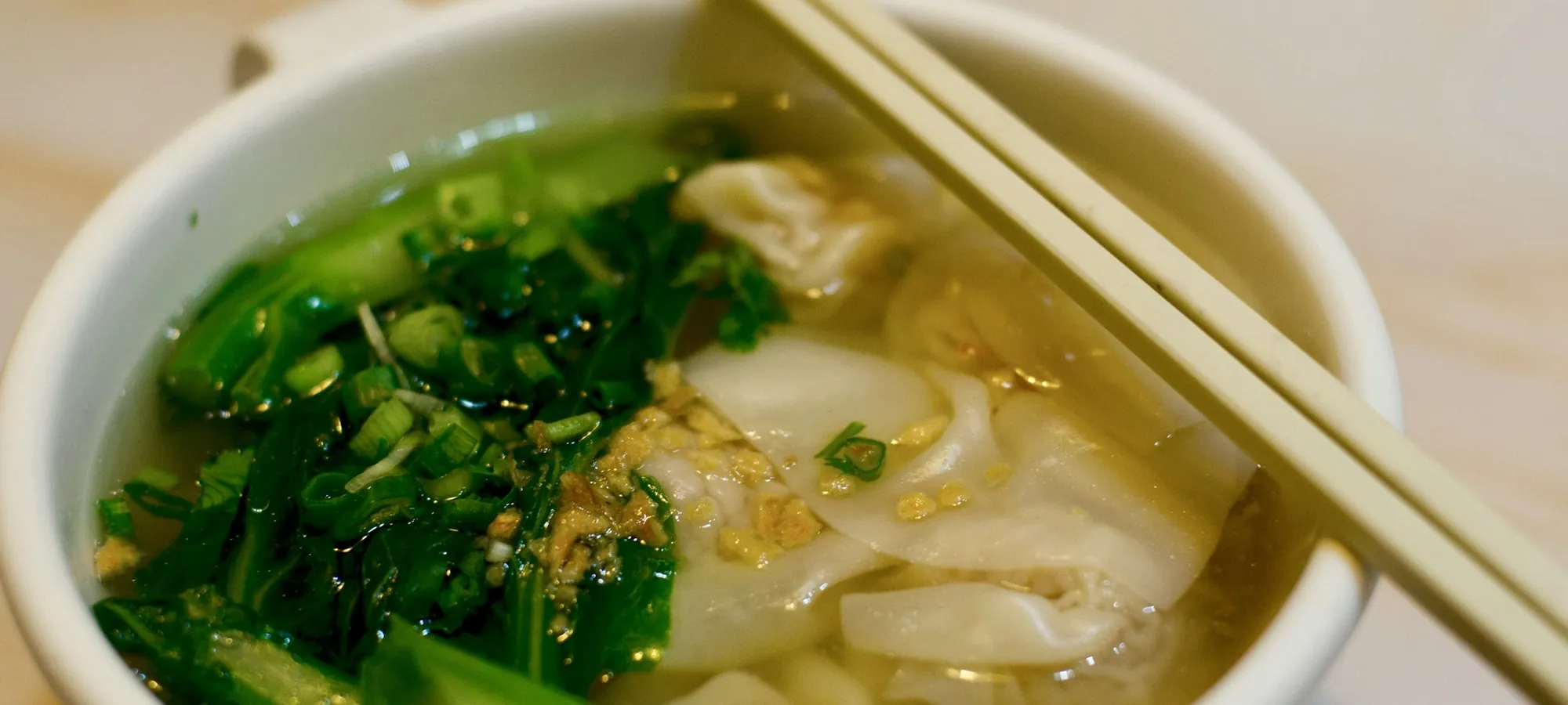 A white ceramic bowl of Chinese soup