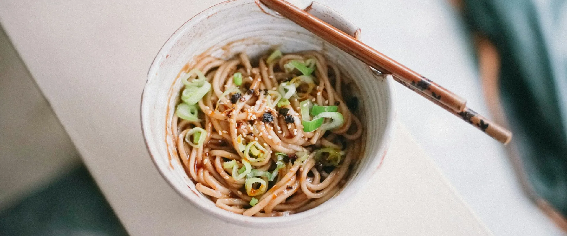 Bowl of Chinese noodles with chopsticks resting on the rim
