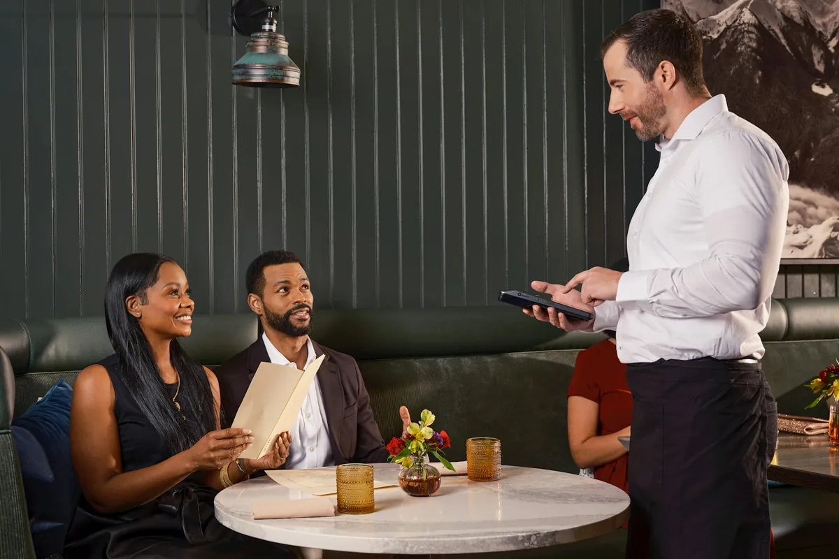 Diners choosing dishes from a menu at a table