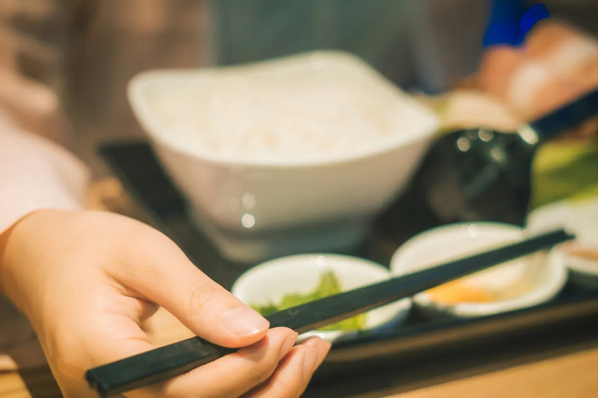 Close view of the fingers gripping chopsticks