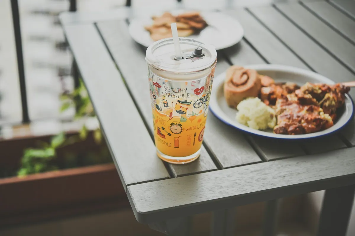 A cold sweet drink beside savory food