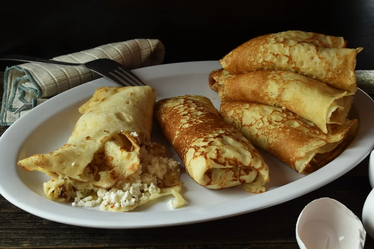 An egg roll beside a dish of dipping sauce