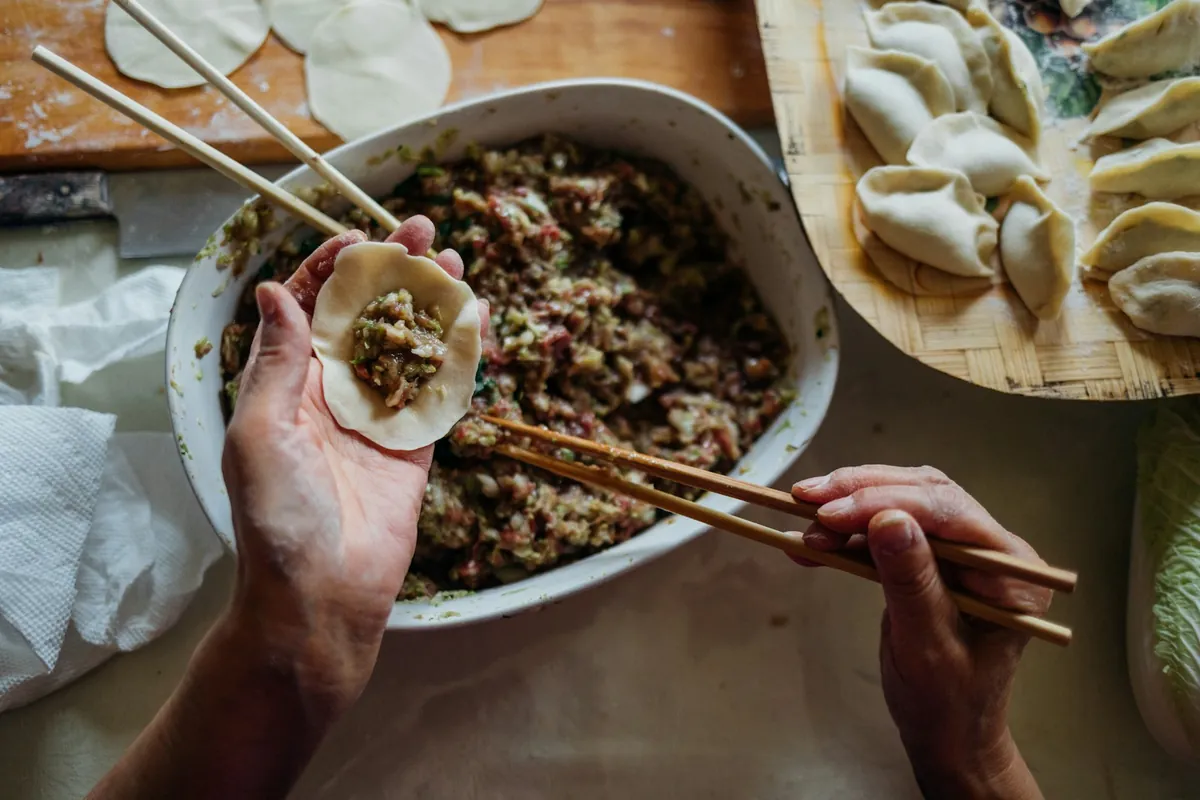 Dumplings being folded by hand