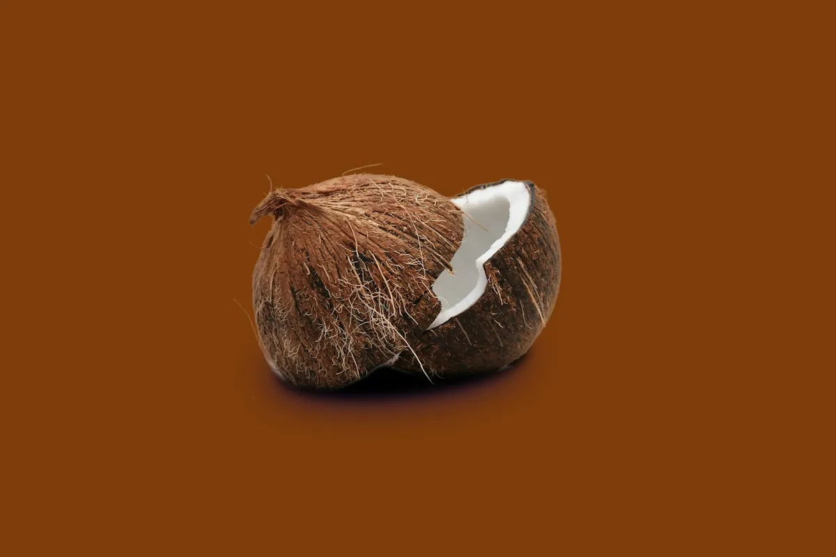 A coconut cut in half showing the white flesh
