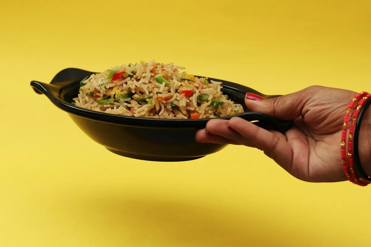 Fried rice served in a bowl with vegetables through it