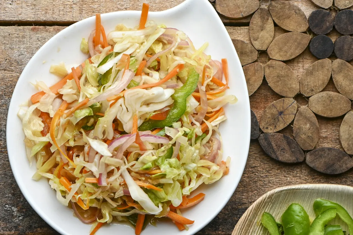 Shredded cabbage and vegetables cooking in a pan