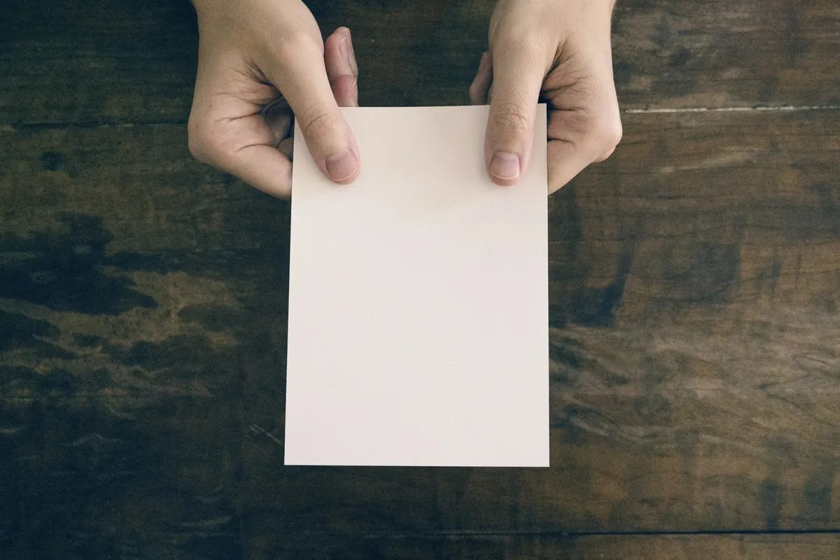A small paper slip held in a hand