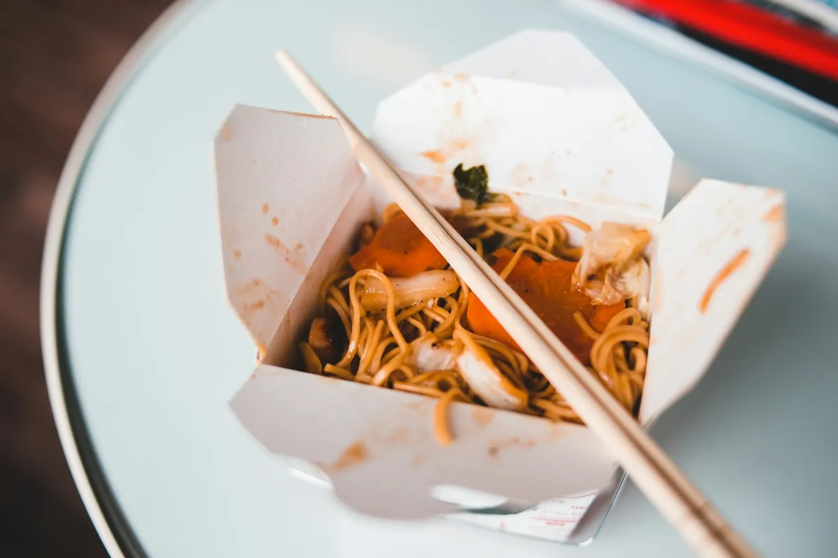 Rice and noodle dishes packed in takeout containers