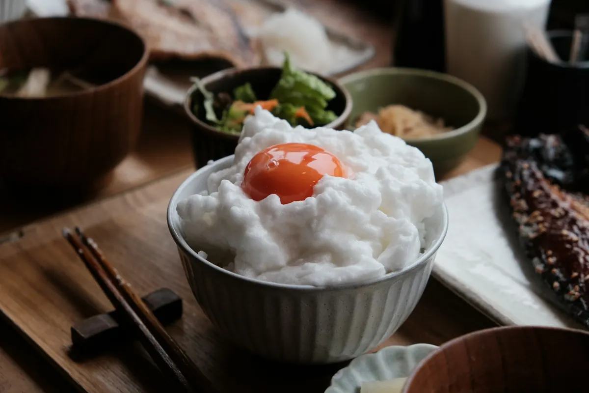A rice bowl lifted while eating with chopsticks