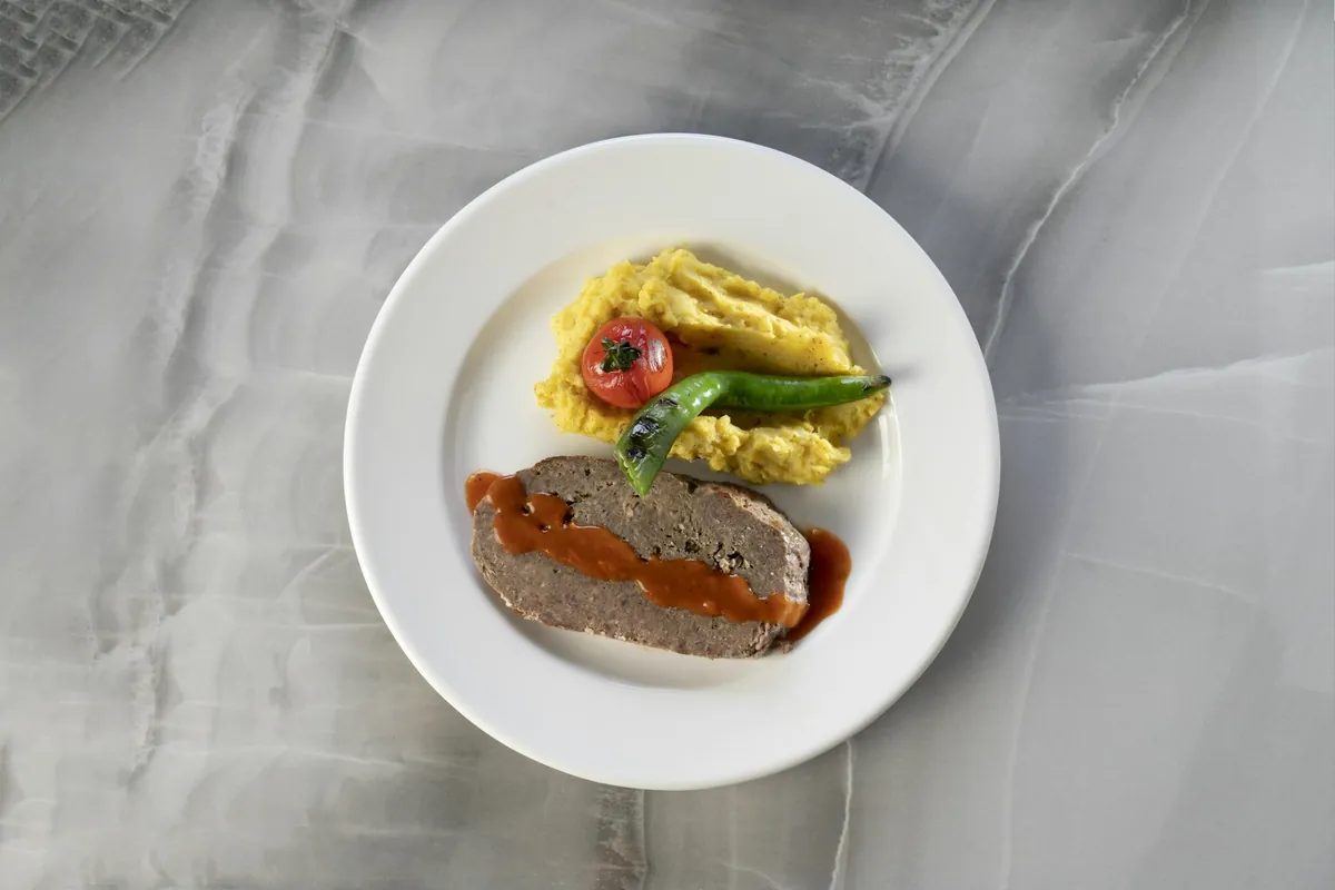 A savory brown sauce being served alongside a cooked dish