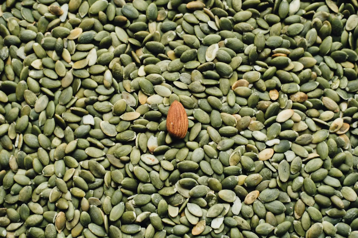 A small bottle of sesame oil beside sesame seeds