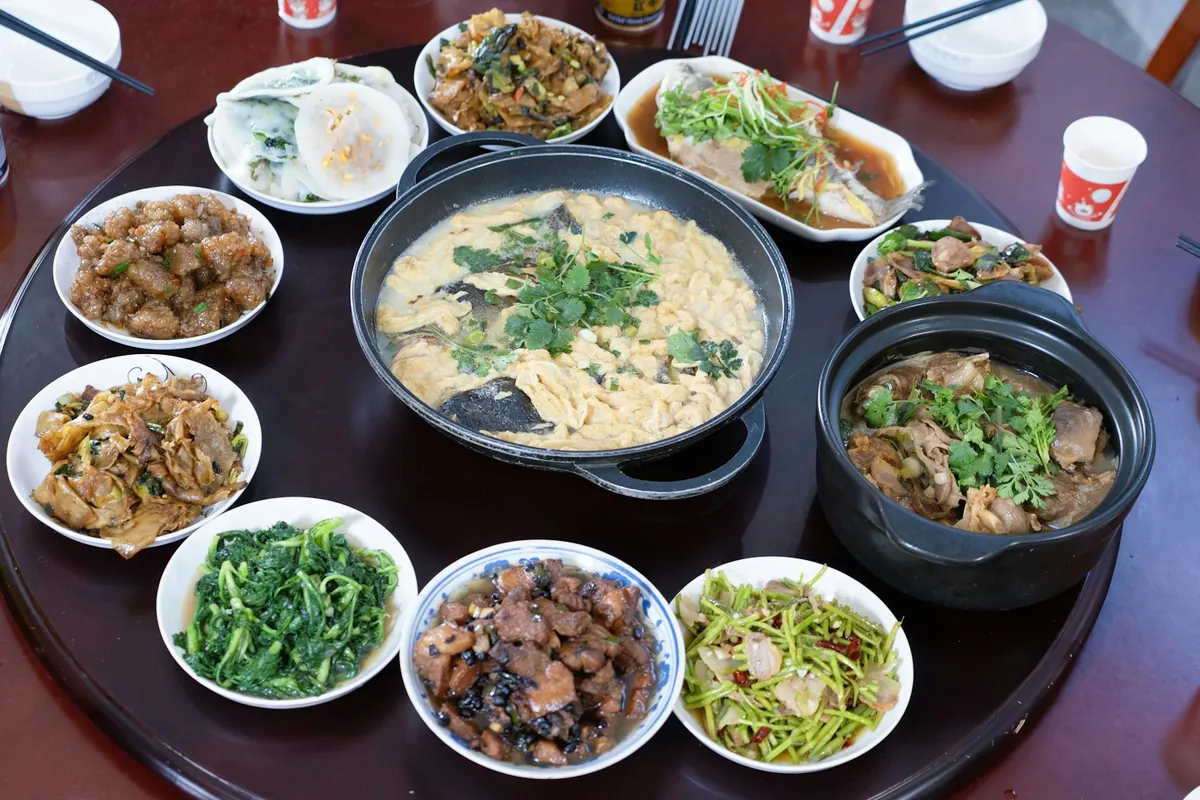 People sharing rice and noodle dishes at a table