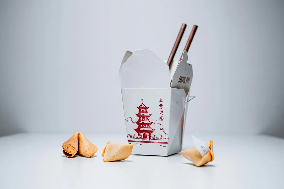 A battered dish packed for takeout with sauce separate