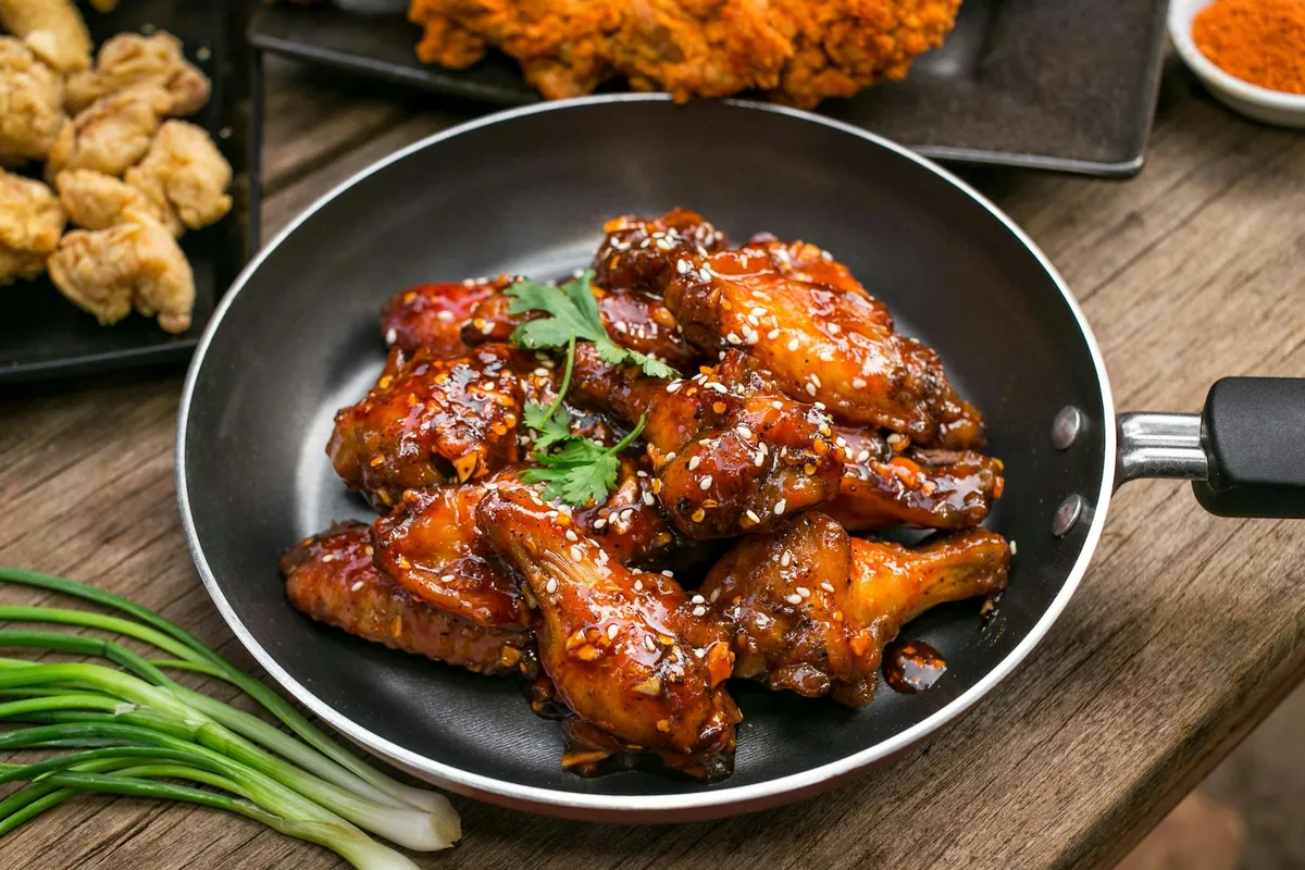 A glossy sweet sauce reducing in a pan