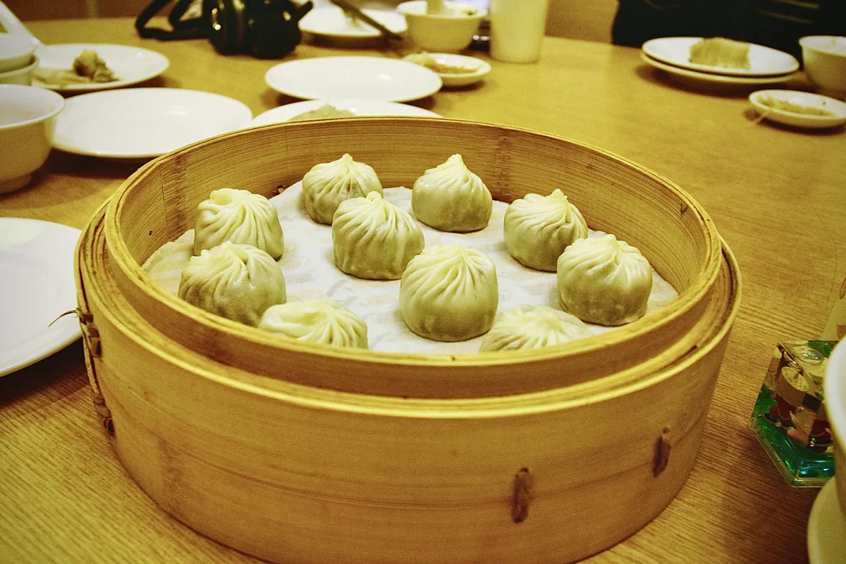 Food being cooked over steam in a bamboo steamer