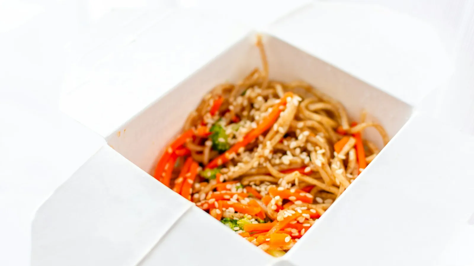 A white folded takeout box with a wire handle